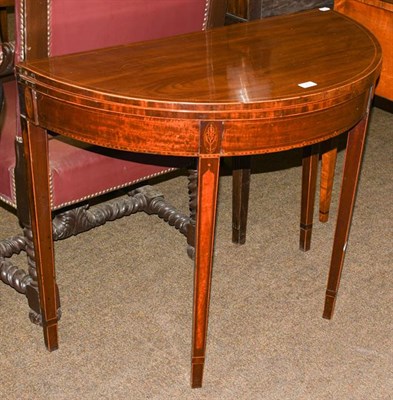 Lot 1205 - A George III mahogany demi lune foldover tea table, with marquetry inlay, raised on square tapering