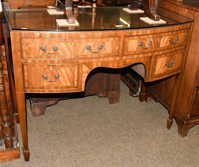 Lot 1214 - A 20th century crossbanded mahogany bow front dressing table, raised on square tapering...