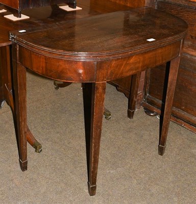 Lot 1221 - An early 19th century mahogany foldover tea table, with reeded mouldings and raised on square...