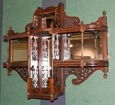 Lot 1262 - A Victorian mahogany mirror backed two-tier hanging wall shelf, with swan neck pediment,...
