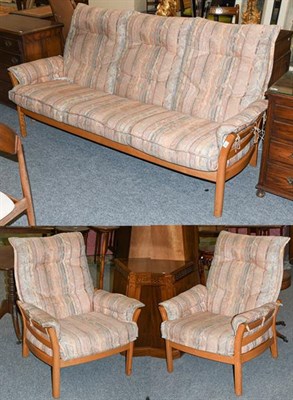 Lot 1296 - An Ercol ladder back three piece suite comprising three seater settee, 190cm by 75cm by 90cm, and a