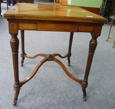 Lot 1685 - An Edwardian Satinwood and Walnut Envelope Card Table, the pivoting top with four triangular leaves