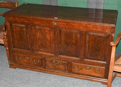 Lot 1325 - An 18th century oak four panelled mule chest with three plank top, with three drawers and raised on