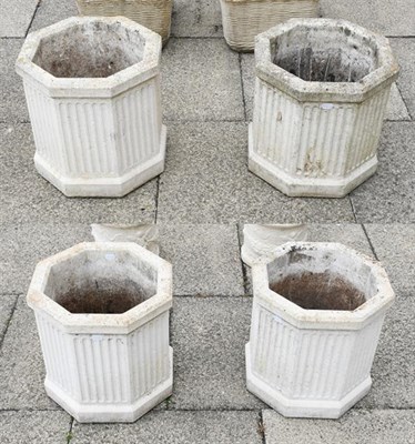 Lot 1350 - A set of four composition garden planters of reeded octagonal form, 41cm high (4)