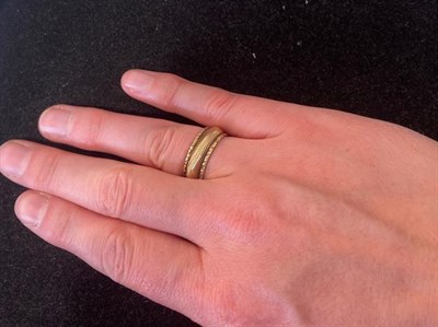 Lot 2211 - A Victorian Band Ring, the yellow textured band with an uneven border, finger size Q see...