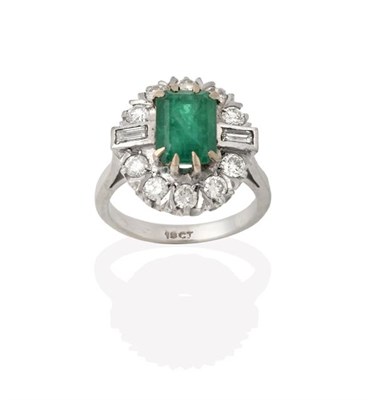 Lot 2226 - An Emerald and Diamond Cluster Ring, the emerald-cut emerald within a border of round brilliant cut