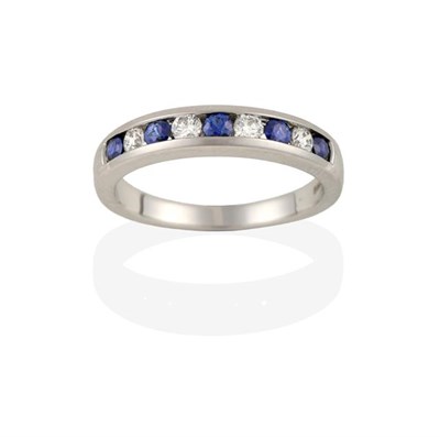 Lot 2242 - An 18 Carat White Gold Sapphire and Diamond Half Hoop Ring, four round brilliant cut diamonds...