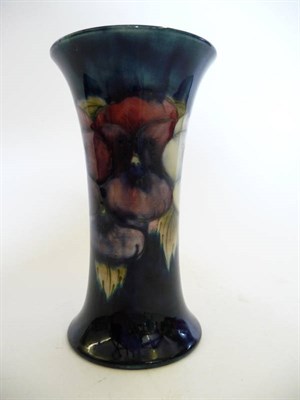 Lot 1722 - A William Moorcroft Pansy Pattern Trumpet Vase, circa 1925, on a blue ground, impressed factory...