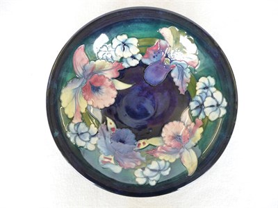 Lot 1724 - A Walter Moorcroft Orchid and Spring Flowers Pattern Bowl, circa 1950, on a blue ground, blue...