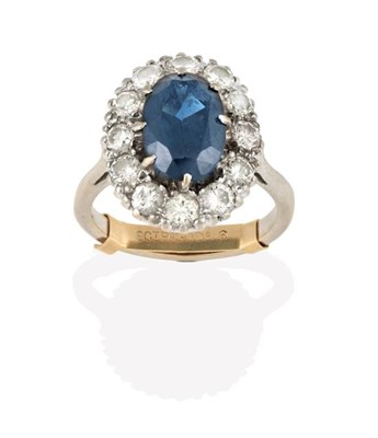 Lot 2277 - A Sapphire and Diamond Cluster Ring, the oval cut sapphire within a border of round brilliant...