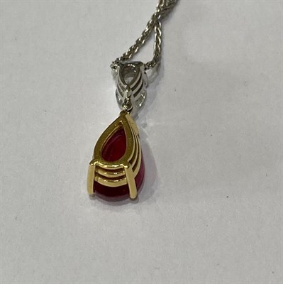 Lot 2282 - A Ruby and Diamond Pendant on Chain, a pear shaped ruby in a yellow claw setting, surmounted by...