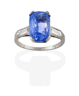Lot 2290 - A Sapphire and Diamond Three Stone Ring, a cushion cut sapphire in a white claw setting, to...