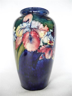 Lot 1726 - A Walter Moorcroft Orchid and Spring Flowers Pattern Vase, circa 1950, swollen shoulders, on a blue