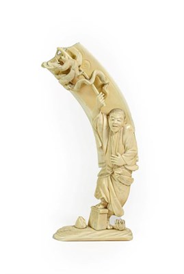 Lot 207 - A Japanese Ivory Okimono, Meiji period, as a standing figure holding a banner with a dragon,...