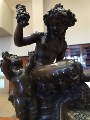 Lot 232 - After Clodion: A Bronze Bacchic Group, with a girl sitting on a rocky outcrop holding a bunch...