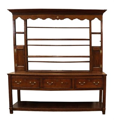 Lot 342 - A George III Oak Open Dresser, late 18th century, the rack with bold dentil cornice above a...