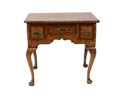 Lot 397 - A Figured Walnut, Crossbanded and Featherbanded Lowboy, early 18th century, the moulded top...