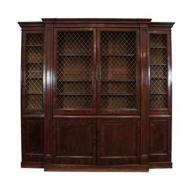 Lot 435 - A Mahogany and Crossbanded Breakfront Bookcase, the upper section with brass grille doors enclosing