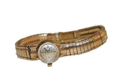 Lot 123 - A lady's 9 carat gold wristwatch, signed Omega, with an integral 9 carat gold bracelet