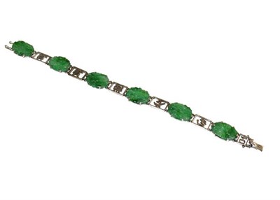 Lot 133 - A Chinese jade bracelet, six engraved jade plaques alternate with fancy white chain links,...