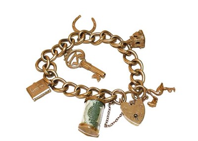 Lot 143 - A 9 carat gold curb link bracelet hung with six charms including a key, a horseshoe, a bible etc