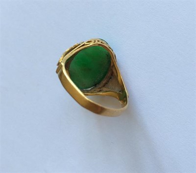 Lot 152 - Two jade rings, oval cabochon jade in yellow claw settings, to textured shoulders (one out of...