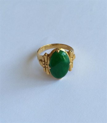 Lot 152 - Two jade rings, oval cabochon jade in yellow claw settings, to textured shoulders (one out of...
