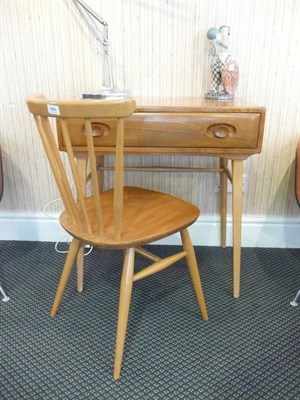 Lot 1880 - A 1960's/70's Ercol Oak Desk, with single drawer and two shaped handles, on four tapering legs...