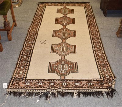 Lot 1004 - Gabbeh rug, the ivory field with linked medallions, framed by border of geometric motifs, 288cm...