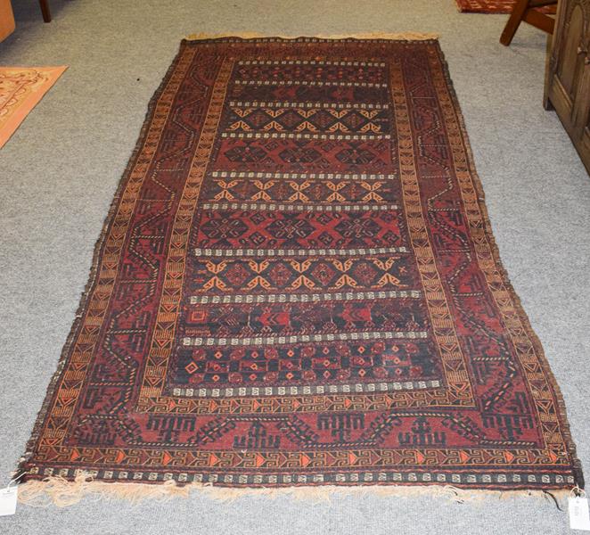 Lot 1010 - Baluch Soumakh rug, the field with indigo and burgundy bands of tribal devices enclosed by...