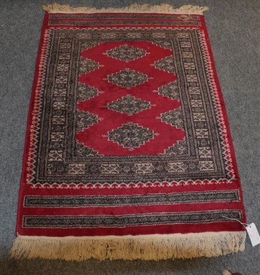 Lot 1011 - Baluch Rug, the crimson field with three crenellated panels comprising hooked guls enclosed by...