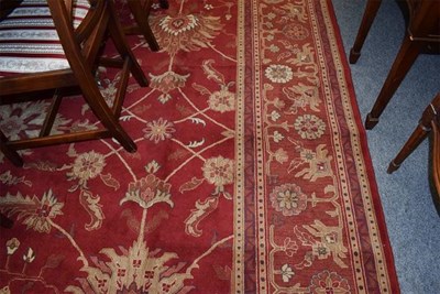 Lot 1012 - A machine made carpet of Zeigler design, the deep terracotta field with an all over design of large