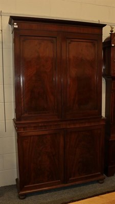 Lot 1113 - A Georgian mahogany bookcase cabinet, the double cupboard doors opening to reveal a shelved...