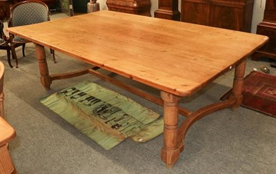 Lot 1129 - A large pine kitchen table, above a central H-stretcher, on turned legs, 240cm by 144cm by 77cm