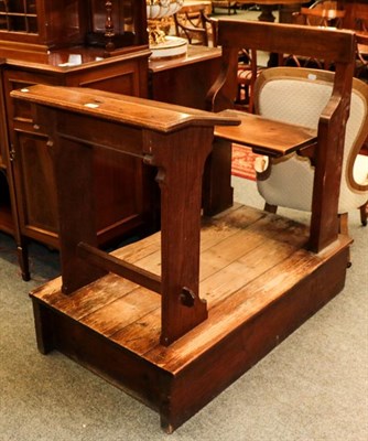 Lot 1149 - Two late Victorian/Edwardian, oak school desks with attached seats and raised on rectangular...