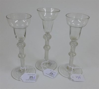 Lot 25 - A Matched Set of Three Air Twist Wine Glasses, circa 1750, the pan topped bowls on double...