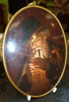 Lot 78 - A German Porcelain Oval Plaque, circa 1900, painted with bearded man in German costume lighting...