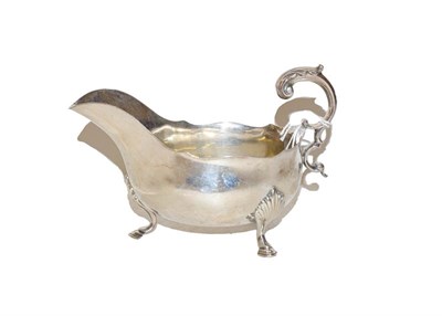 Lot 47 - An Edward VII silver sauce boat by Henry Atkin, Sheffield, 1905, boat shaped and on three pad...