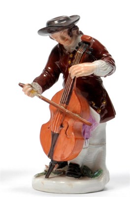 Lot 97 - A Meissen Porcelain Figure of a Cellist, circa 1750, standing wearing at black hat, brown...