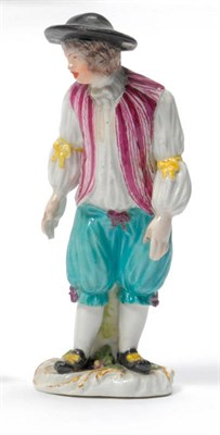 Lot 100 - A Meissen Porcelain Figure of a Youth, circa 1750, standing wearing a black hat, pink striped...