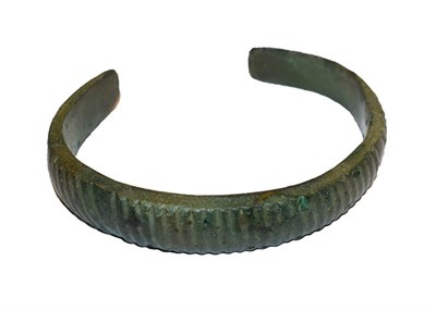 Lot 261 - A Roman bronze torque bangle with reeded decoration, 8cm wide