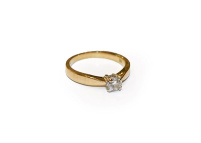 Lot 276 - A diamond solitaire ring, the round brilliant cut diamond in a white four claw setting, to a yellow