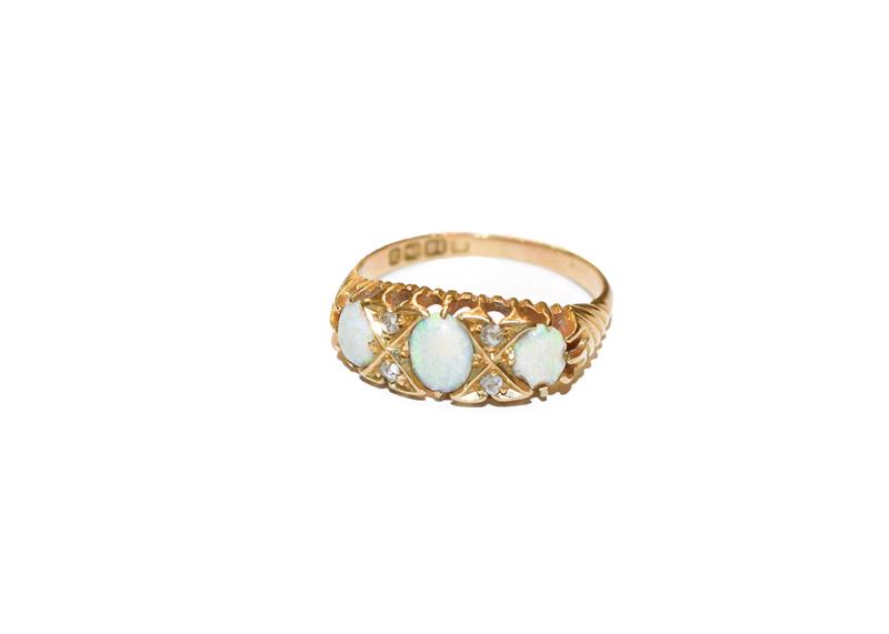 Lot 300 - An 18 carat gold opal three stone ring, the graduated oval cabochon opals with rose cut diamond...