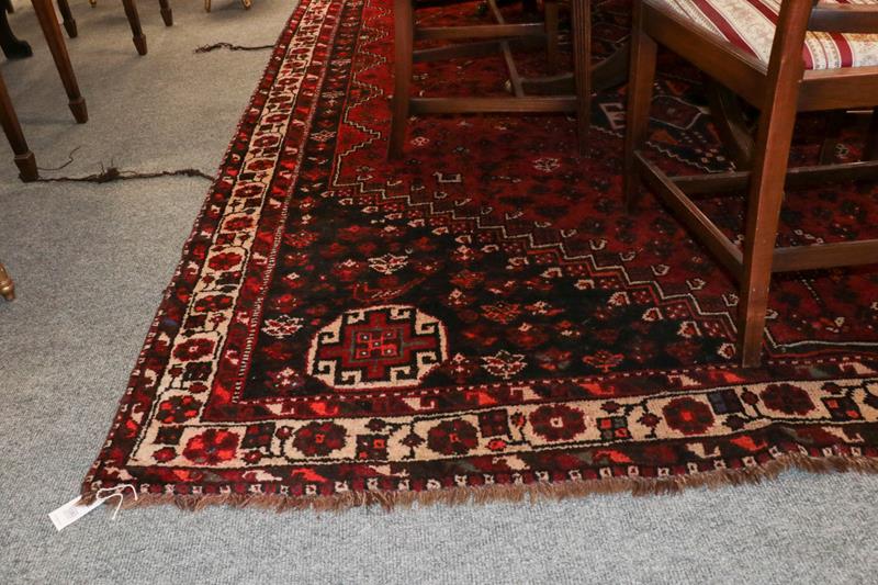Lot 1080 - Kashgai Carpet, the brick red field with three linked stepped medallions framed by spandrels...