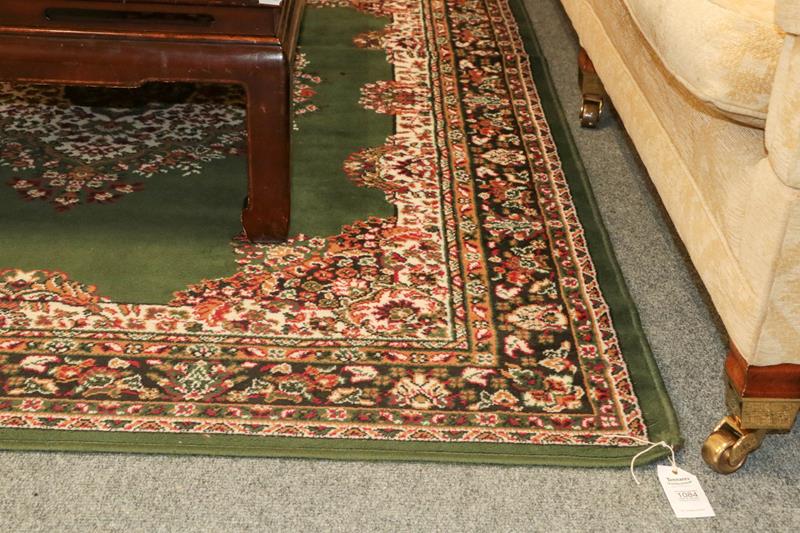 Lot 1084 - Machine made Rug of oriental design, the British racing green field with central medallion...