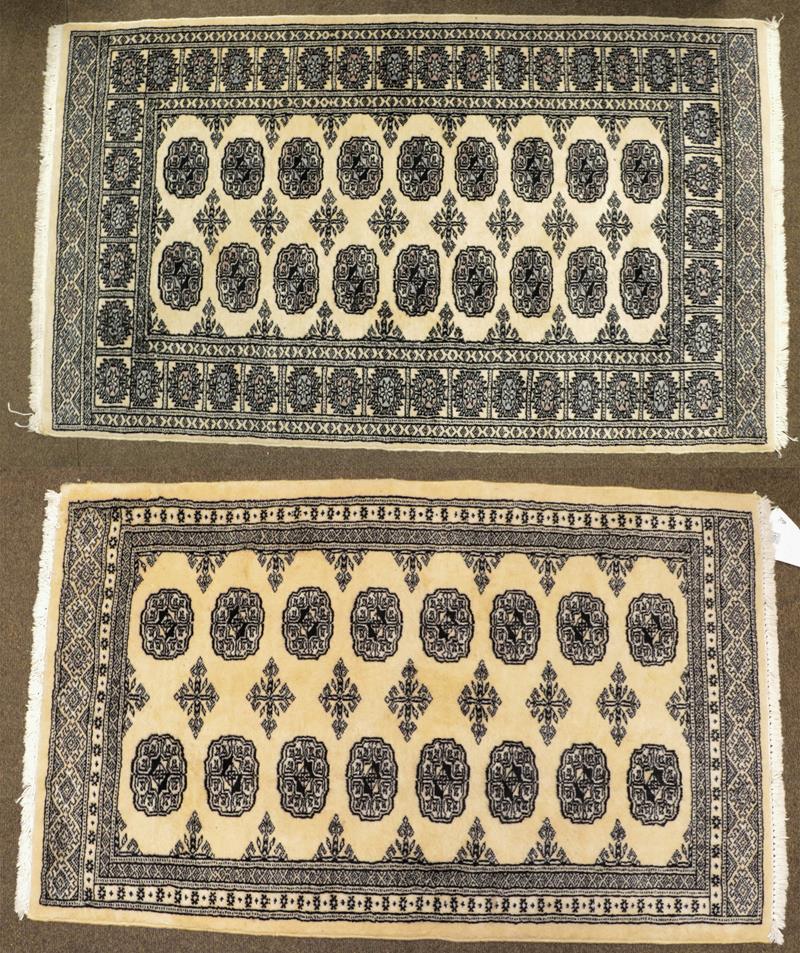 Lot 1091 - A Kashmiri 'Bukhara' Rug, the ivory field with columns of guls enclosed by narrow borders,...