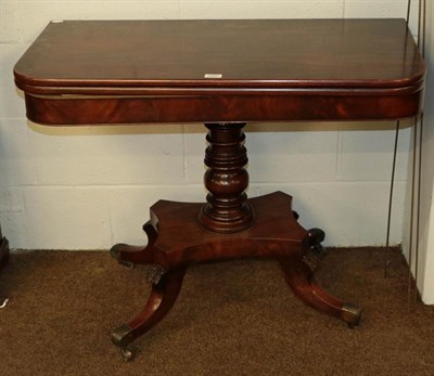 Lot 1101 - A Regency mahogany fold-over tea-table, raised on a turned centre pedestal on carved scroll...