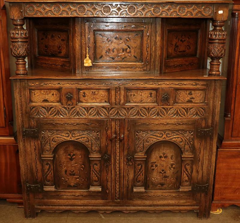 Lot 1103 - A 17th century style heavily carved oak court cupboard with marquetry inlay and bulbous...