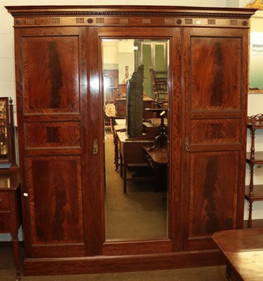 Lot 1108 - An Edwardian mahogany mirror fronted triple wardrobe, crossbanded and with egg and dart...