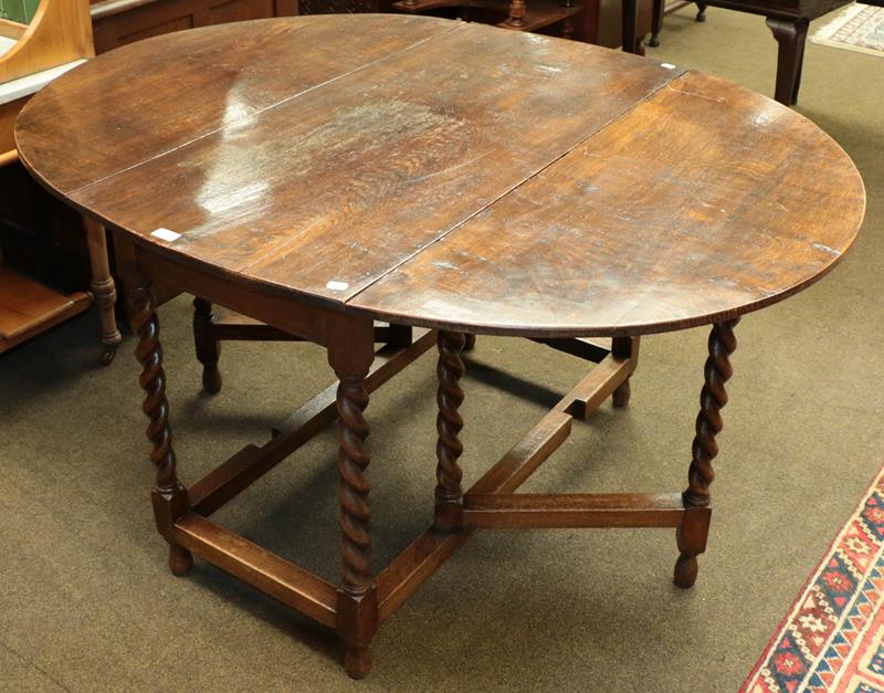 Lot 1121 - An early 20th century oak barley twist gate-leg dining table, 141cm by 108cm (open) by 73cm
